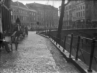 818704 Afbeelding van de beschadigde balustrade langs de Oudegracht te Utrecht; op de achtergrond het Stadhuis ...